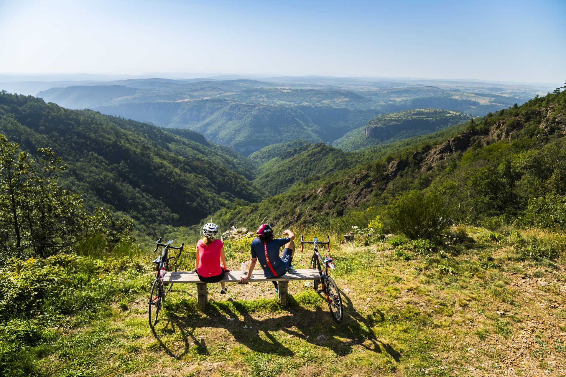 Deux cycliste assis sur un banc qui contemplent le paysage